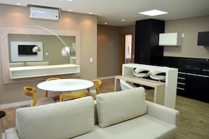 A modern kitchen with black cabinets, a white countertop, and a built-in oven.
