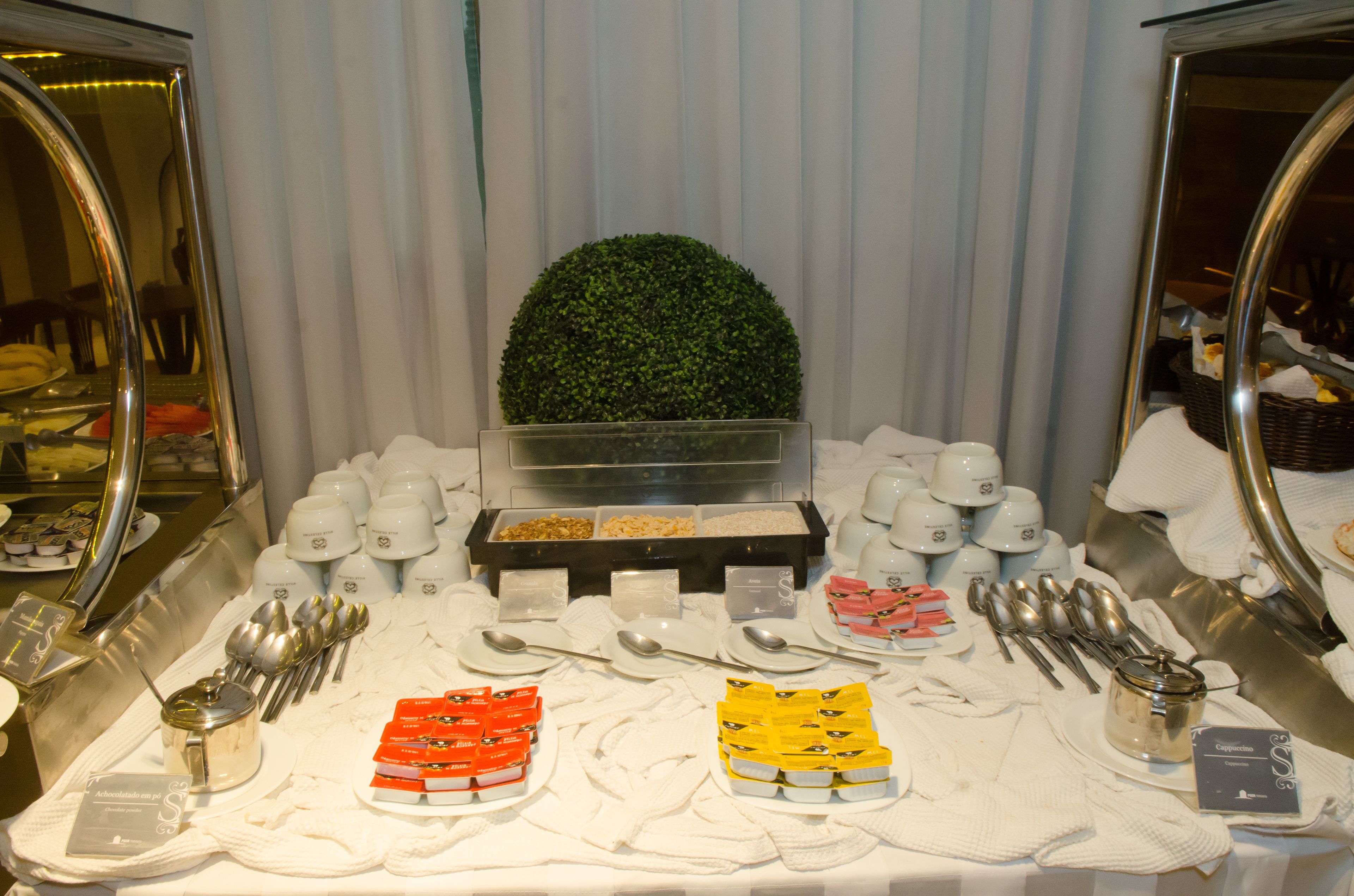 A buffet setup with various food items, utensils, and condiments.