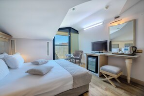 Habitació d'hotel amb un llit, un escriptori amb un ordinador, una cadira i una televisió.