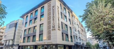 A hotel with a modern facade, large windows, and a prominent sign.