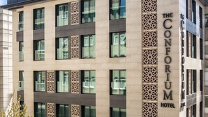 A modern hotel with a prominent facade, multiple windows, and a decorative vertical panel. - The Conforium Hotel (Istanbul)