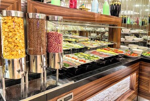 A buffet with various food items and containers.