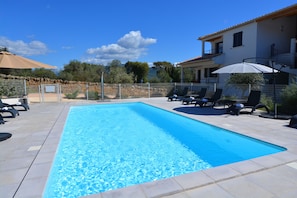 Piscine extérieure, parasols de plage, chaises longues