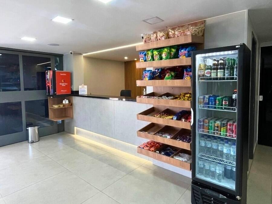 A hotel reception area with a counter, a vending machine, and a trash bin.