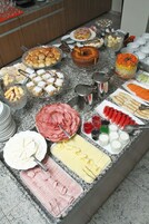 Un bufé con diferentes opciones de comida, incluyendo pasteles, carnes y postres.