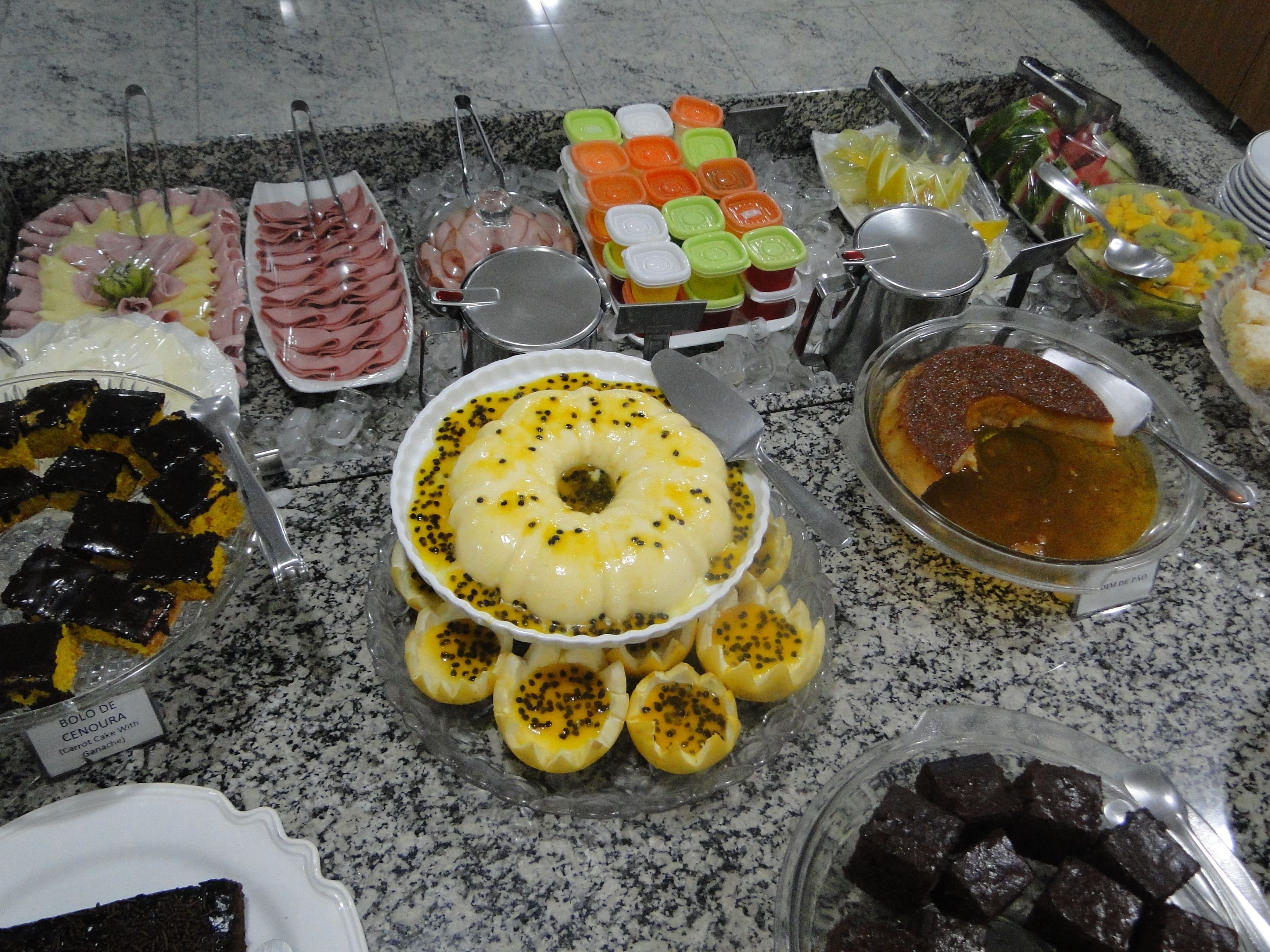 Un bufé con diversos platos, incluyendo un pastel de caramelo, un tazón de sopa y varias bandejas de comida.