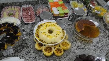 Un bufé con diversos platos, incluyendo un pastel de caramelo, un tazón de sopa y varias bandejas de comida.