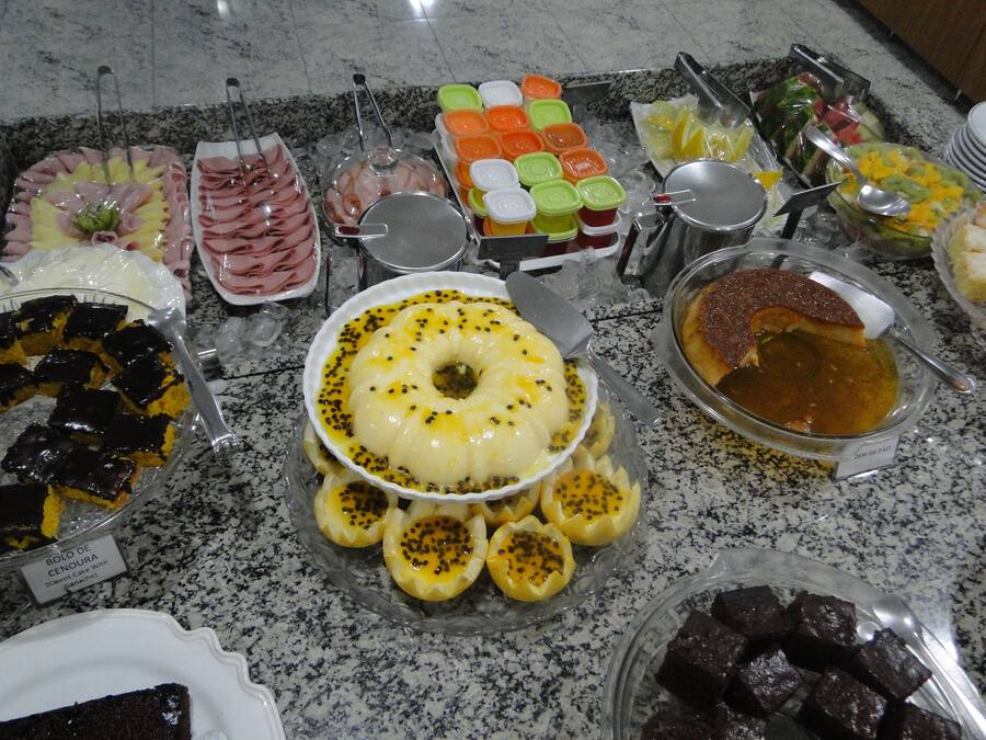 Un bufé con diversos platos, incluyendo un pastel de caramelo, un tazón de sopa y varias bandejas de comida.