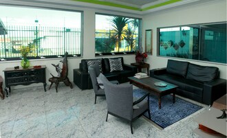 Una sala de estar moderna con un sofá, sillones, una mesa de centro y un aparador de madera decorativo.