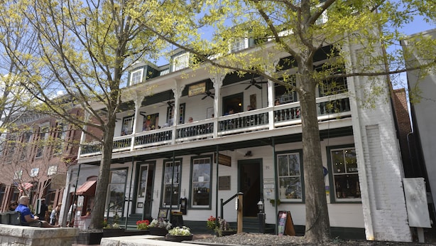 A two-story building with a balcony, large windows, and a sign indicating a restaurant. - Hall House Hotel (Dahlonega)
