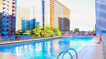 Una piscina al aire libre, sillones reclinables de piscina