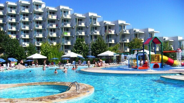 A swimming pool area with a water slide and lounge chairs. - Hotel Laguna Garden (Albena)