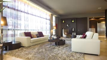 A modern living room with two white sofas, a fluffy rug, and a coffee table.
