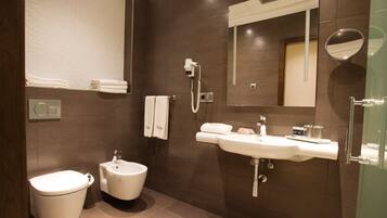A modern bathroom with a bidet, toilet, and sink.