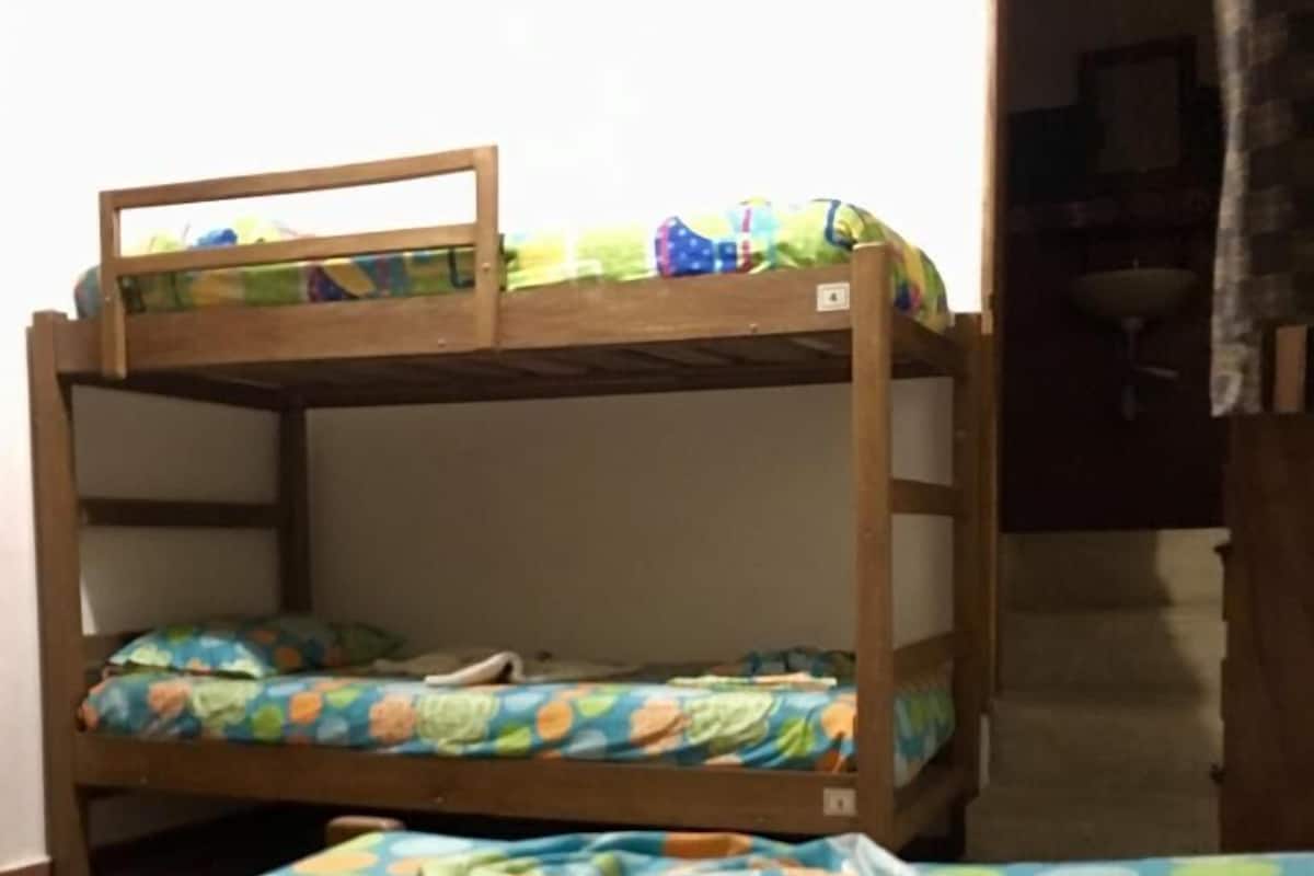 Een stapelbed met een onderbed en een bovenbed, beide met kleurrijke beddengoed.