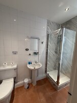 Un baño con inodoro, lavamanos y ducha.