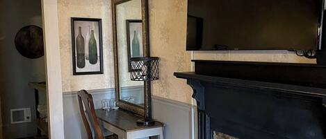 A living room with a fireplace, a television, and a dining area with a chair and table.