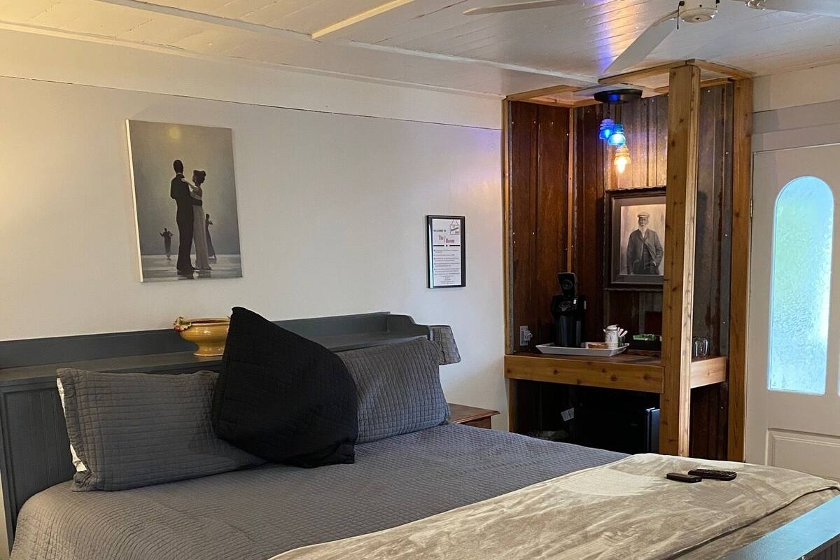 A neatly arranged bedroom with a bed, pillows, a bedside table, and a nightstand.