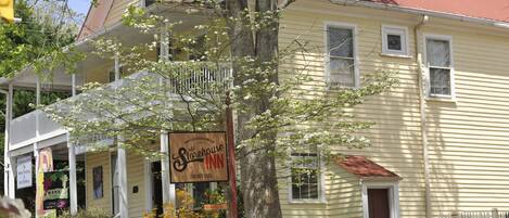 A yellow building with a porch and a sign for 'Old Storehouse Inn'.