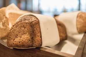 A loaf of bread with sesame seeds on a wooden surface. - Sommarøy Arctic Hotel Tromsø (Tromsø)