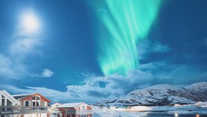 A snowy landscape with a house and a river. - Sommarøy Arctic Hotel Tromsø (Tromsø)