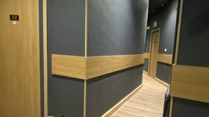 A hallway with wooden flooring, dark walls, and a door labeled '32'. - Le Strasbourg Hotel (Montpellier)