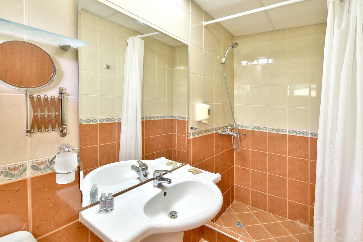 shower, hair dryer, slippers, towels