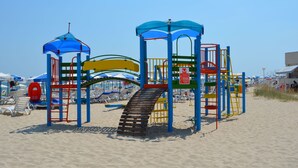 A beach playground with slides and climbing structures.