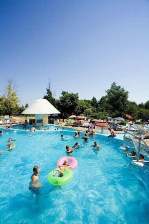 A large outdoor swimming pool with multiple people and inflatable rings. - Hotel Orchidea Park All Inclusive (Albena)