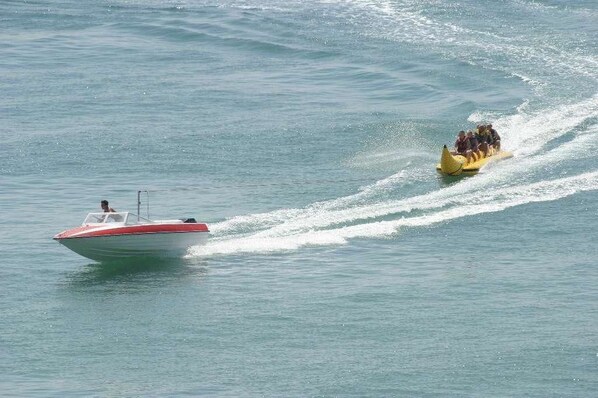 A speedboat towing a yellow inflatable raft with passengers. - Hotel Orchidea Park All Inclusive (Albena)