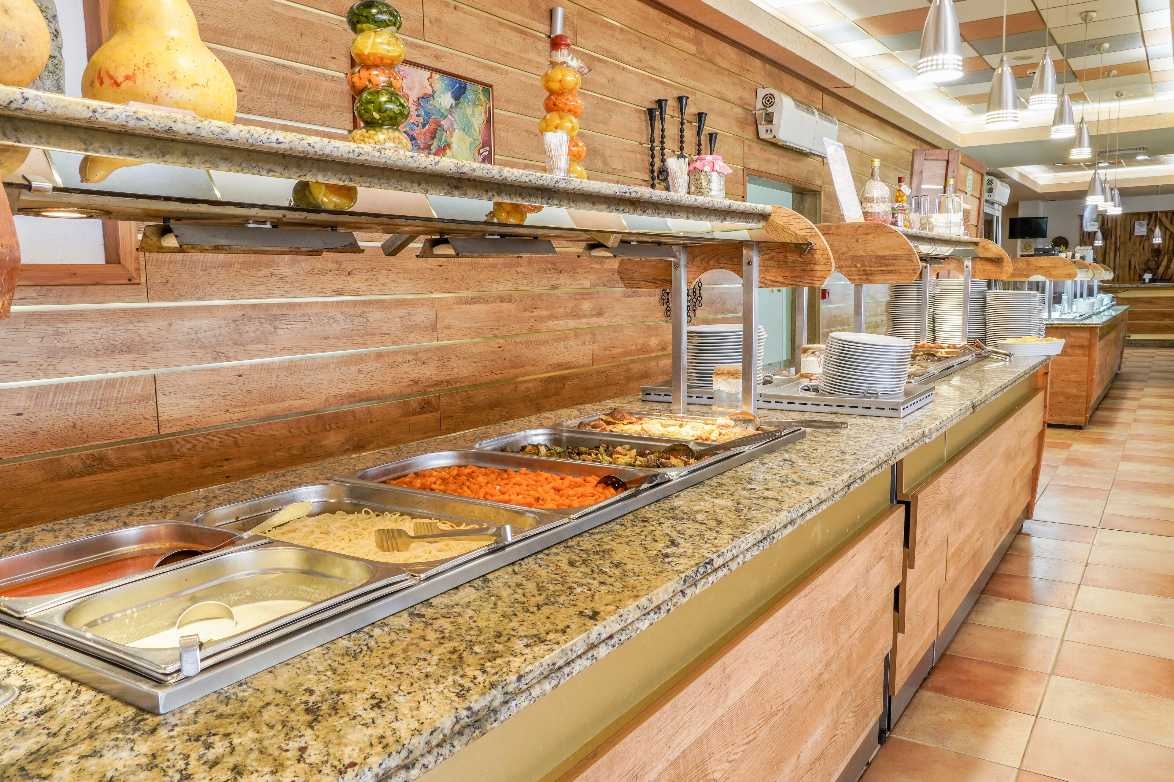 A buffet with various food items and utensils.