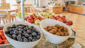 A buffet with bowls of blueberries, apples, peaches, and other fruits. - Hotel Sandy Beach (Albena)