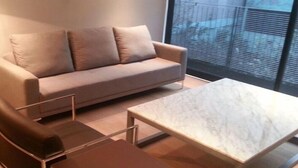A modern living room with a sofa, a coffee table, and a floor lamp. - Polanco by O (Mexico City)