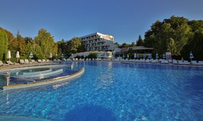 Una piscina cubierta, una piscina al aire libre de temporada, sombrillas