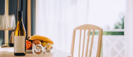 A table with a bottle of wine, a banana, and a glass on a wooden table.
