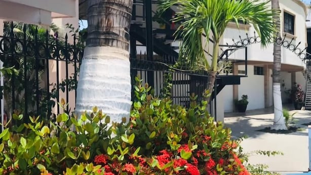 A building with a white facade, a black metal staircase, and a yellow curb. - Hotel Marina Topolobampo (Topolobampo)