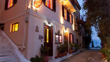 Experience the classic charm of this traditional pension, featuring a welcoming entrance, potted plants, and a historic staircase.