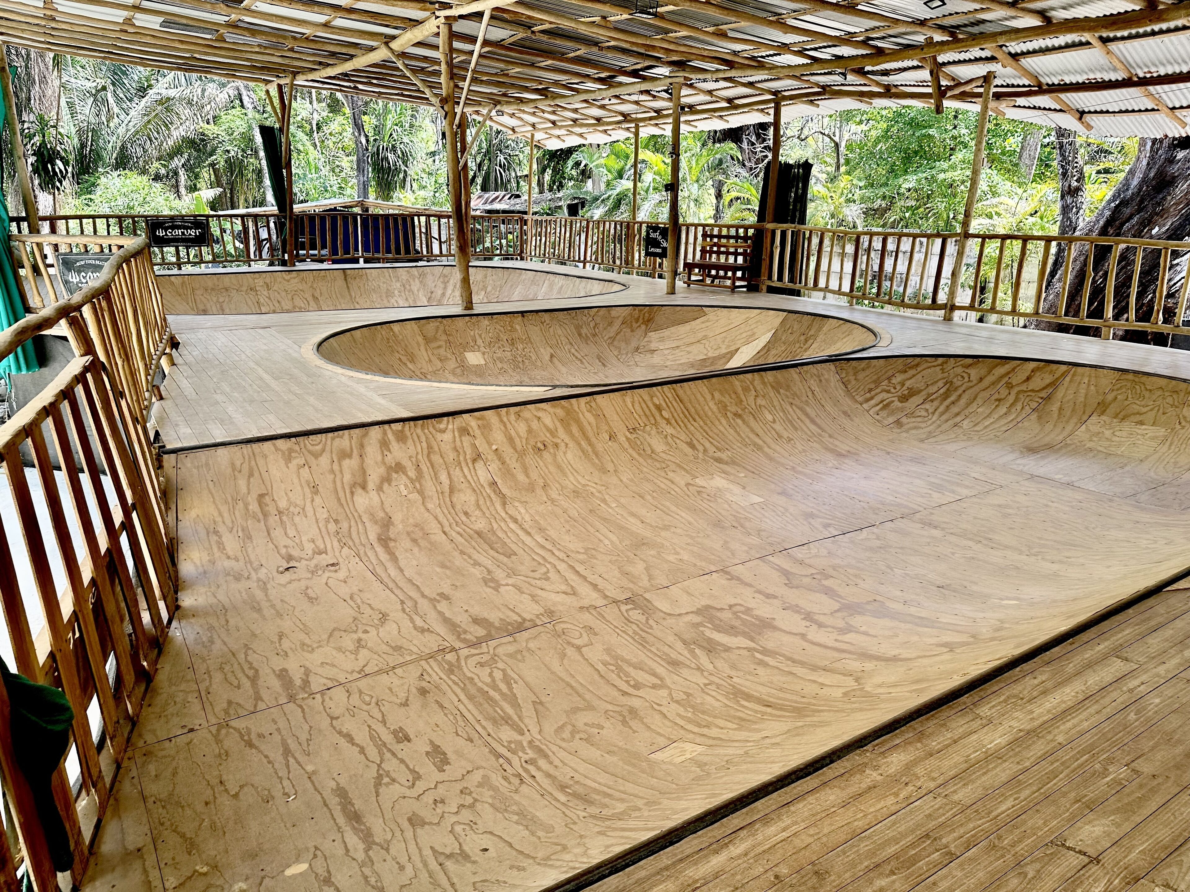 Una pista de skate de madera con una rampa curva y un banco.