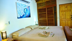 Une chambre d’hôtel avec un grand lit, une porte en bois et un tableau accroché au mur.