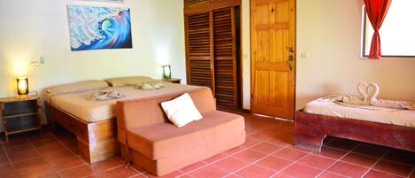 Um quarto com uma cama, um sofá, um guarda-roupa de madeira e um quadro na parede.