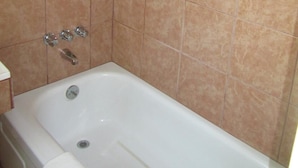 A bathroom with a bathtub, a shower, and a toilet. - Relax Inn (Cottage Grove)