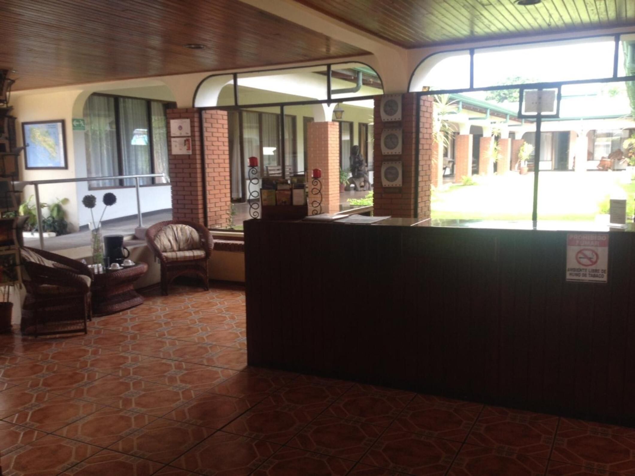 A reception area with a tiled floor, a reception desk, and seating area with chairs.