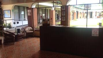 A reception area with a tiled floor, a reception desk, and seating area with chairs.