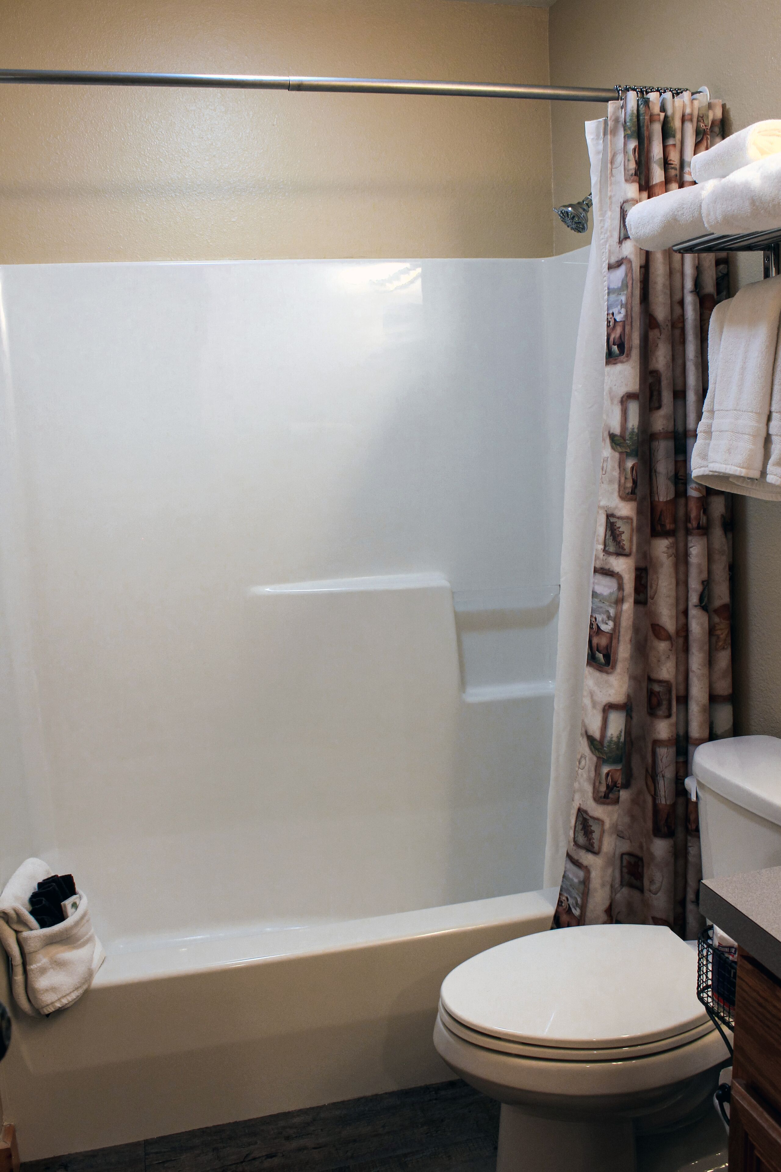 A bathroom with a bathtub, toilet, and shower curtain.