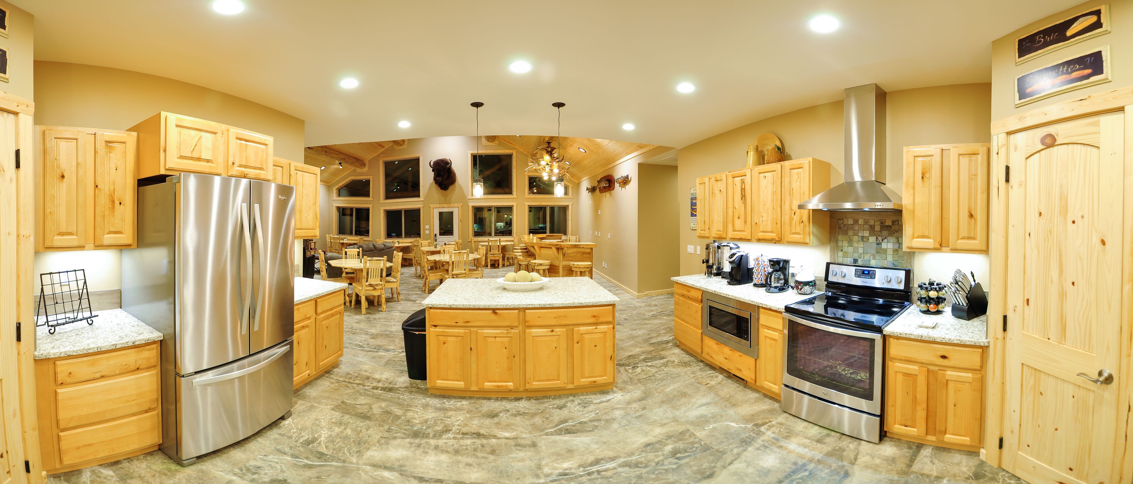 A spacious kitchen with wooden cabinets, stainless steel appliances, and a central island.