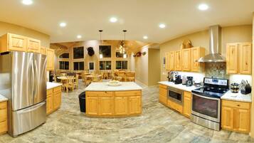 A spacious kitchen with wooden cabinets, stainless steel appliances, and a central island.