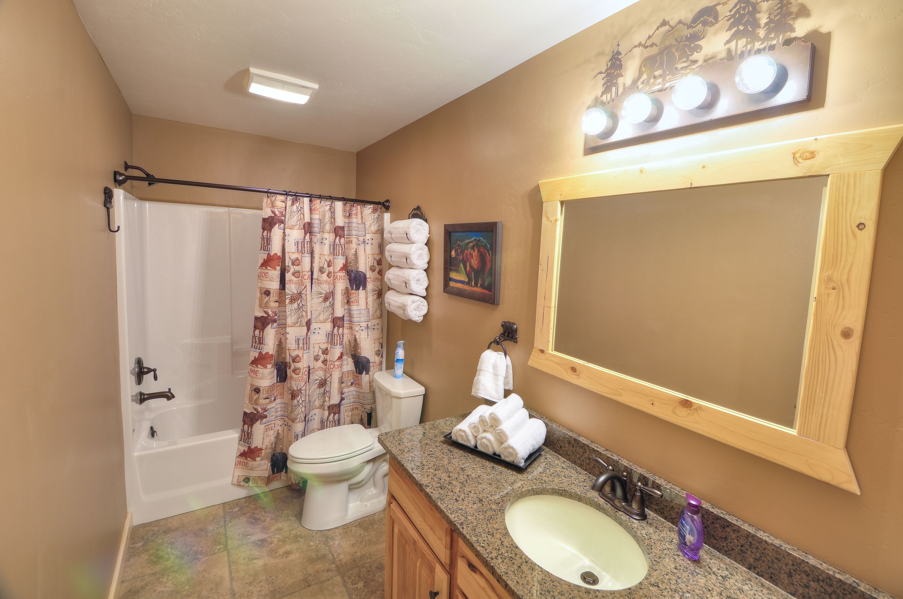 A bathroom with a bathtub, toilet, sink, and a large mirror.