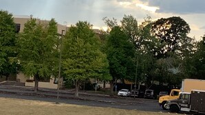 A parking lot with trees and a building in the background. - Riverside Inn Dallas (Dallas)