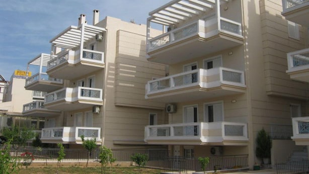 A multi-story residential building with balconies, a flat roof, and a sign indicating a hotel. - Hotel Cybele (Lykovrysi-Pefki)