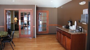 A kitchen with wooden cabinets, a granite countertop, and a built-in sink. - Green Acres Hotel (Pittsfield)